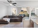 Cozy living room featuring a comfortable sofa, ceiling fan, and sliding glass doors at 9534 W Park Village Dr, Tampa, FL 33626