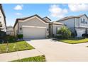 Well-maintained home exterior with a spacious driveway, lovely lawn, and gray paint at 10303 Malvasia Ave, Riverview, FL 33578