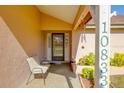 A view of a welcoming front porch with a chair and plants, showcasing the entrance to the home at 10833 96Th N St, Largo, FL 33773