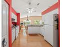 Bright kitchen featuring white cabinets, stainless steel appliances, and wood-look flooring at 11800 Ivywood Pl, New Port Richey, FL 34654
