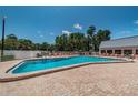 Beautiful community pool with clear water, a brick deck, and a variety of seating options at 11800 Ivywood Pl, New Port Richey, FL 34654