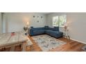 Inviting living room features wood flooring, a cozy blue sofa, and large windows for plenty of natural light at 1253 Union St, Clearwater, FL 33755