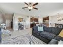 Inviting open-concept space featuring a large sofa, ceiling fan, and seamless flow to the kitchen at 12775 Maple Bonsai Dr, Riverview, FL 33579