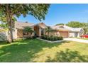 Charming single Gathering home featuring manicured lawn, mature trees, and a two car garage at 1285 Salt Lake Dr, Tarpon Springs, FL 34689