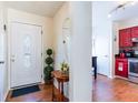 Welcoming foyer with wood floors, decorative mirror, and a glimpse into the adjacent kitchen at 1728 Mill Run Cir, Tampa, FL 33613