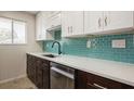 Beautiful kitchen with stainless steel appliances, white counters, and stylish blue backsplash at 1821 Bough Ave # 4, Clearwater, FL 33760