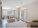 Open concept dining room features wood floors, wainscoting, large windows, and updated lighting at 2256 Pantucket Dr, Wesley Chapel, FL 33543