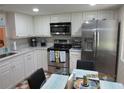 Modern eat-in kitchen with white cabinets, stainless steel appliances, and a cozy breakfast nook at 2555 Royal Pines Cir # A, Clearwater, FL 33763