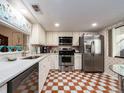 Well lit kitchen featuring stainless steel appliances, marble countertops, and patterned flooring at 2555 Royal Pines Cir # A, Clearwater, FL 33763