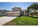 Inviting two-story home with manicured lawn, arched entryway, and a convenient three-car garage at 2629 Timacqua Dr, Holiday, FL 34691