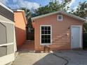 Backyard and garage area with concrete block walls, concrete slab, and some landscaping at 2903 N 16Th St, Tampa, FL 33605