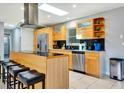 Modern kitchen with wood cabinetry, stainless steel appliances, skylight, and sleek black countertops at 3044 Golden Rain Dr, Sarasota, FL 34232