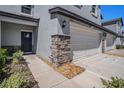 Stylish townhome showcases stone accents, a convenient two-car garage, and a welcoming front door at 32091 S Pop Ash N Pl, San Antonio, FL 33576