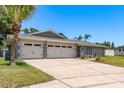 The home has a two car garage, concrete driveway, and lovely green lawn at 3241 Brushwood Ct, Clearwater, FL 33761