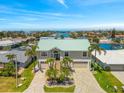 Beautiful waterfront home with vibrant green roof and convenient two-car garage, plus tropical landscaping at 3505 Seaway Dr, New Port Richey, FL 34652