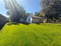 Expansive backyard featuring a lush lawn and mature trees at 40709 Melrose Ave, Zephyrhills, FL 33540
