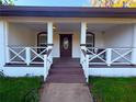 Inviting front porch with decorative railing, dark trim and matching front door at 40709 Melrose Ave, Zephyrhills, FL 33540