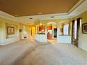 Spacious open-plan living room with high ceilings flowing into the kitchen area, ideal for entertaining at 446 Noble Faire Dr, Sun City Center, FL 33573
