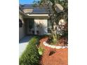 Charming front entrance with landscaped garden, decorative hanging plants and tasteful exterior design at 4504 Cabbage Palm Dr, Valrico, FL 33596