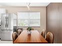 Bright dining area featuring stainless steel refrigerator, modern lighting, and decorative accent wall at 5519 Homewood Dr, Sarasota, FL 34232