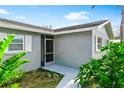 Inviting home entrance with a screened front door, clean walkway, and lush tropical landscaping at 5519 Homewood Dr, Sarasota, FL 34232