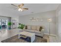 Cozy living room featuring a plush sofa, elegant lighting, and views into the adjoining kitchen and outdoor patio at 5591 15Th N Ave, St Petersburg, FL 33710