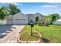Inviting home with a paver driveway, attached garage, and meticulously maintained front yard at 6130 Japonica Ct, New Port Richey, FL 34655
