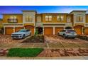 Townhome exterior featuring a two-car garage, manicured landscaping and paver driveway and sidewalk at 7339 Skybird Rd # 7339, Bradenton, FL 34209