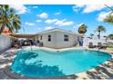 Backyard featuring a large, kidney-shaped swimming pool and covered patio with lounge chairs at 7800 Causeway N Blvd, St Petersburg, FL 33707