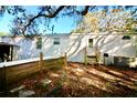 Exterior shot of a white home, wooden fence, new wooden steps, and a grassy backyard at 9161 Codel Loop, New Port Richey, FL 34654