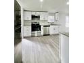 Well-lit kitchen showcasing stainless steel appliances and modern white cabinetry at 9161 Codel Loop, New Port Richey, FL 34654