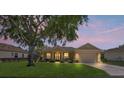 Beautiful home at dusk with well-kept lawn, attached two car garage, and a cozy front porch at 9398 N Burnam Dr, Weeki Wachee, FL 34613