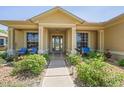 Inviting front porch with comfortable seating, lush landscaping, and a charming walkway at 9398 N Burnam Dr, Weeki Wachee, FL 34613
