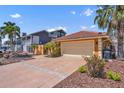 Charming single-story home with a terra cotta roof, stucco exterior, and a paved driveway with mature landscaping at 1008 Mandalay Ave, Clearwater, FL 33767