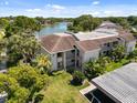 Exterior view of the condo showcasing tropical landscaping and a glimpse of the tranquil lake at 108 Lakeview Ct # 108, Oldsmar, FL 34677