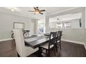 Dining room with dark hardwood floors, table with six chairs, and decorative bicycle console table at 11118 Running Pine Dr, Riverview, FL 33569