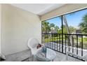 Relaxing screened balcony featuring outdoor seating and a view of the lush community at 13602 Frigate Ct # N201, Clearwater, FL 33762