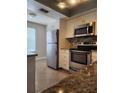 Modern kitchen with stainless steel appliances, granite countertops, and tiled backsplash at 14061 Notreville Way, Tampa, FL 33624
