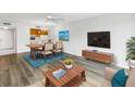Open-concept living room and dining area with wood-look flooring and a mounted TV at 14255 Rosemary Ln # 8219, Largo, FL 33774
