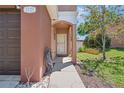 Charming home's front entrance featuring a covered porch and well-maintained landscaping at 1725 Sommarie Way, Tarpon Springs, FL 34689