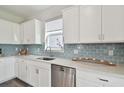 Modern kitchen features stainless steel appliances, white cabinetry, subway tile backsplash, and quartz countertops at 17652 Ramble On Way, Land O Lakes, FL 34638