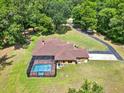 Lovely home featuring a screened-in pool, set amidst verdant landscaping at 24498 Casey Rd, Brooksville, FL 34601