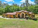 Beautiful one-story home with a covered entryway and meticulously maintained landscaping at 24498 Casey Rd, Brooksville, FL 34601