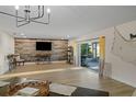 Open living space with a decorative accent wall, modern lighting, and sliding door access to the outdoor patio at 4968 Southshore Dr, New Port Richey, FL 34652