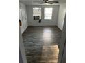 Living room with dark wood laminate flooring, two windows, and a ceiling fan at 5829 32Nd N St, St Petersburg, FL 33714