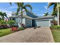 Beautiful two-story coastal home featuring a brick driveway and a spacious three-car garage at 718 Manns Harbor Dr, Apollo Beach, FL 33572