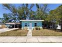 View of a light blue single-story home with a front yard and trees, offering a cozy curb appeal at 769 53Rd N Ter, St Petersburg, FL 33703