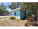 Side view of a light blue single-story home with landscaping, windows, and walkway at 769 53Rd N Ter, St Petersburg, FL 33703