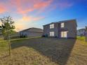 View of the home's backyard with grass, a set of sliding glass doors, and an adjacent property at 7782 Sail Clover Ln, Zephyrhills, FL 33540