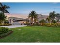 Charming single-Gathering home featuring a well-manicured lawn and elegant landscaping with palm trees at 813 Manns Harbor Dr, Apollo Beach, FL 33572
